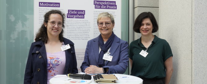 3 Teilnehmende am Tag der Pflegenden vor Plakatwand
